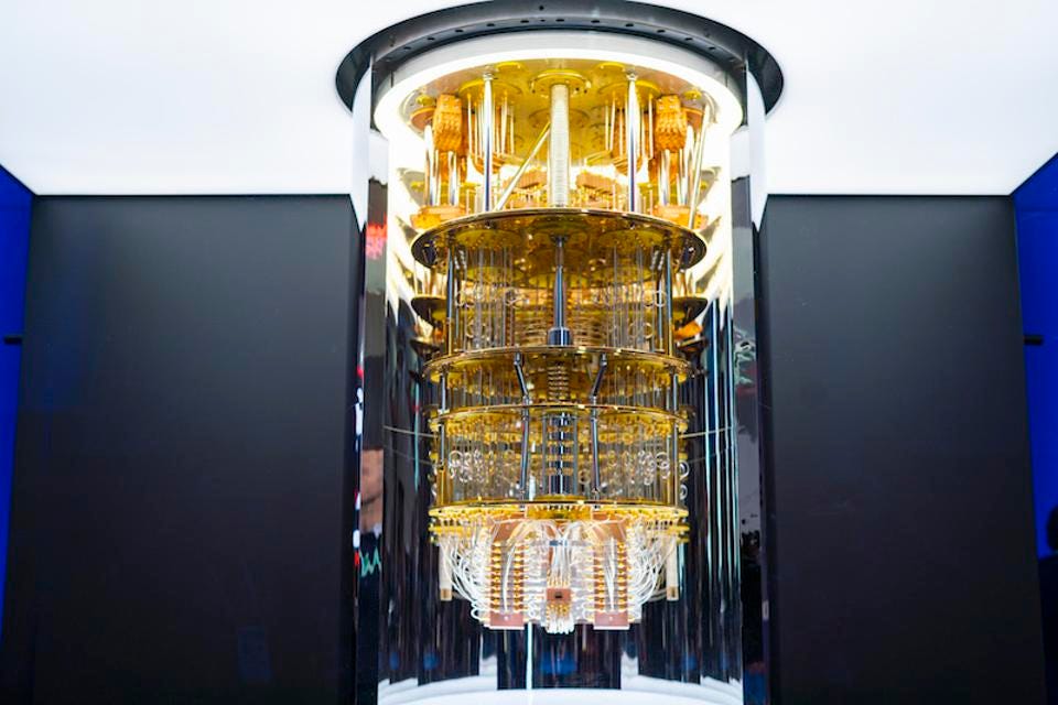 The meme is a photo of a quantum computer, with a caption "Quantum computer: 0s and 1s, 0s and 1s, 0s and 1s..." implying that the computer is stuck in a loop, unable to perform any meaningful calculations.